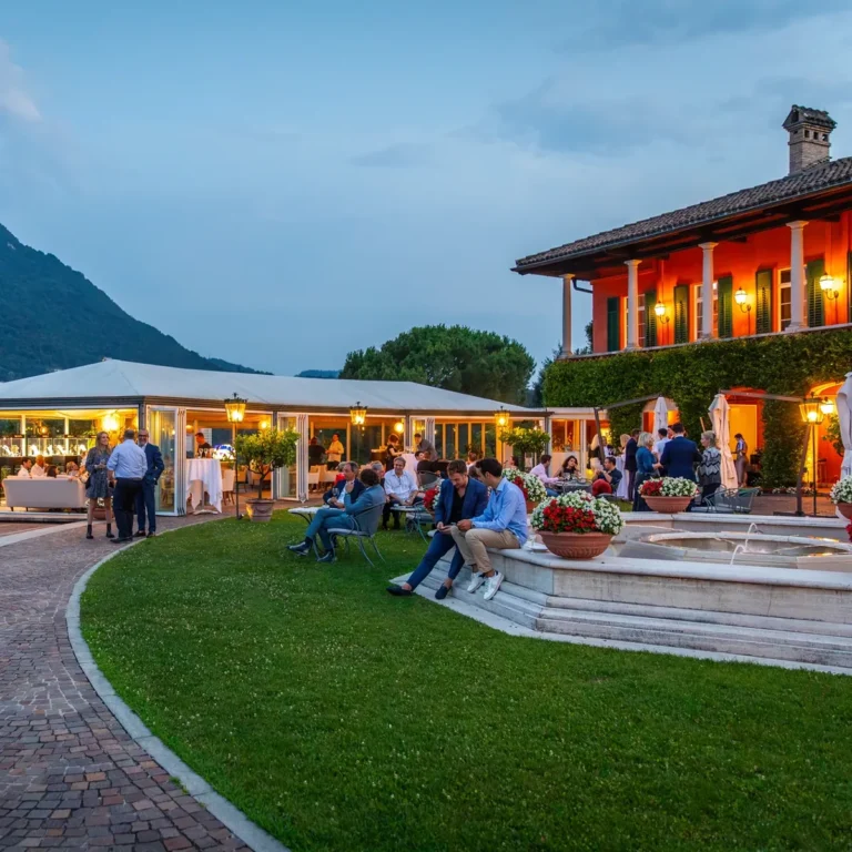 Ospiti sulla terrazza di una villa durante un evento al tramonto